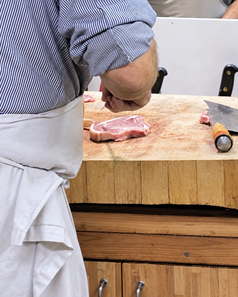 Découpe d'une pièce de viande sur le billot — geste d'artisan boucher